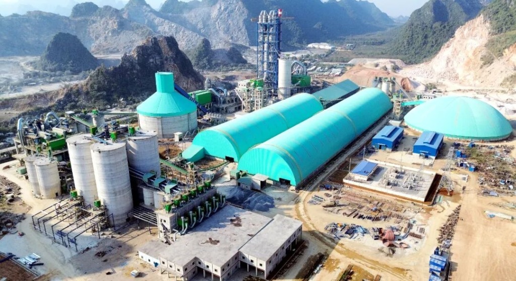 Cement plant with turquoise sheds in Vietnamese mountains