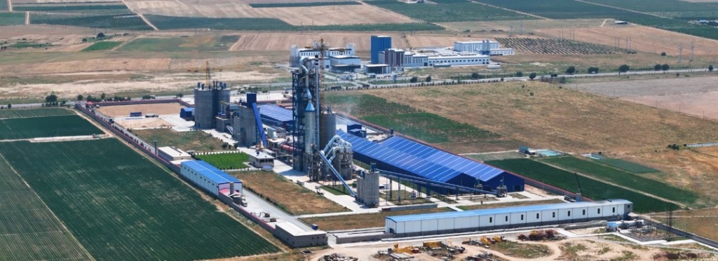 Blue-roofed cement plant in flat Uzbekistan plains