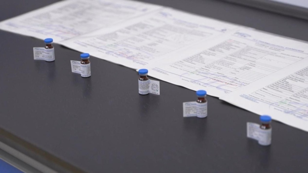 Pharmaceutical reference standard vials with blue caps on laboratory table