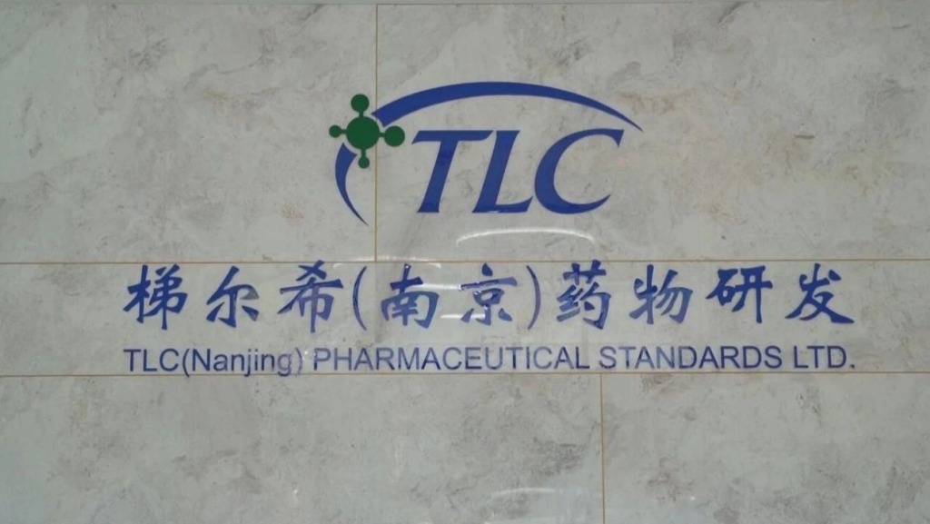 TLC Nanjing Pharmaceutical Standards company logo on office wall